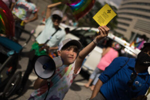 Boy holding a chant card and a megaphone.