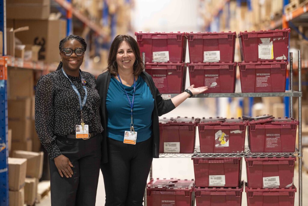Ellen Odai Alie and Julie Clairmont, Director of Supply Chain Operations, pose with the shipment of bandages.