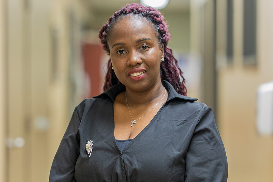 Kaywana Malcolm debout dans le couloir devant le bureau du programme On avance.